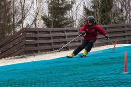 a skier skiing fast on a downhill artificial slope