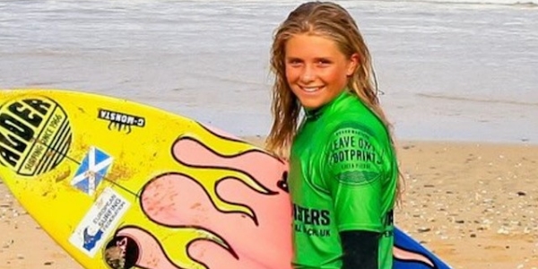Callie Cruickshank on the beach with her surf board