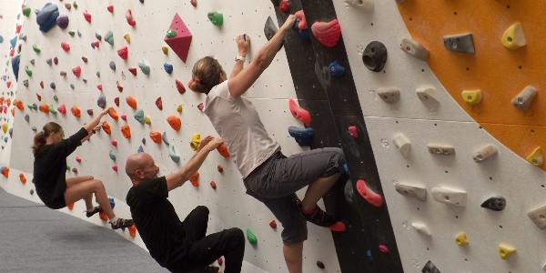 A group of adults enjoying a climb on the bouldering wall