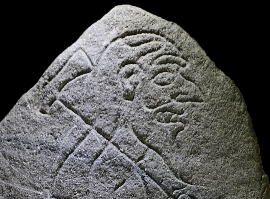 carved Pictish stone of a man holding an axe over his shoulder.