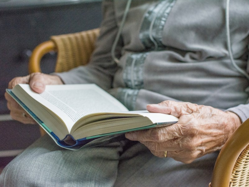 elderly person reading a book