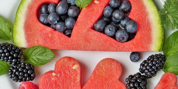 A plate of fruit including blueberries, watermelon and blackberries