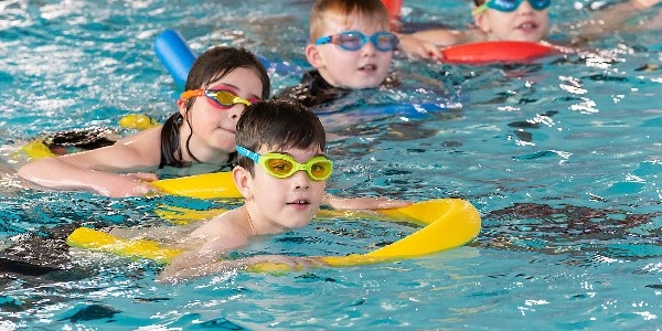 A group of children in the pool with floats