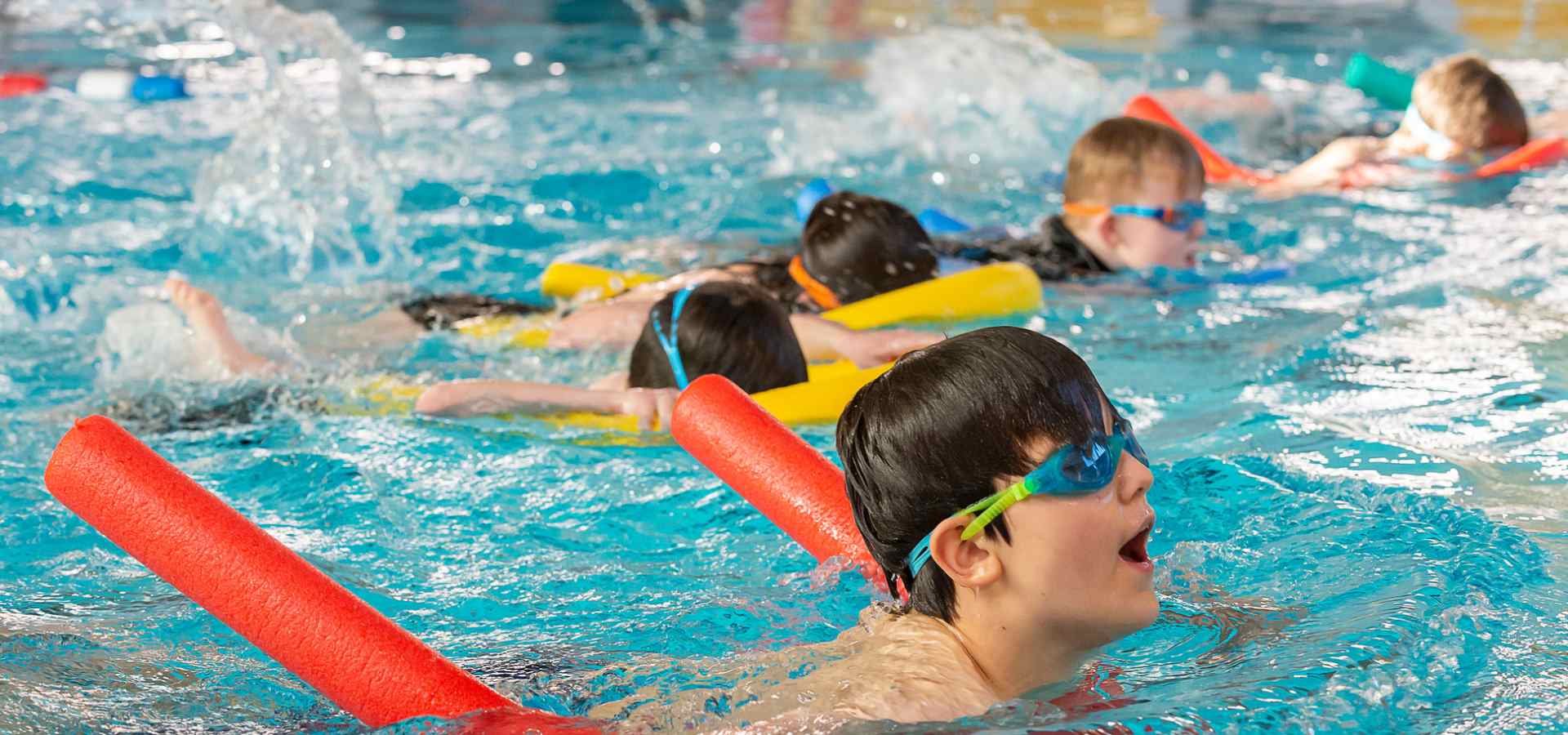 A group of young children having fun in a swimming class