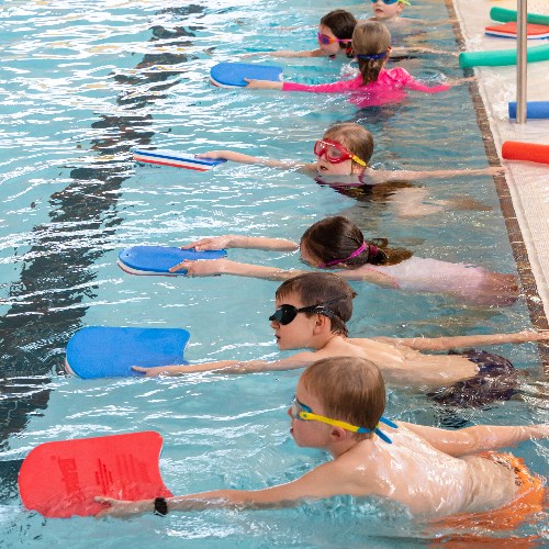 A group of children swimming with floats
