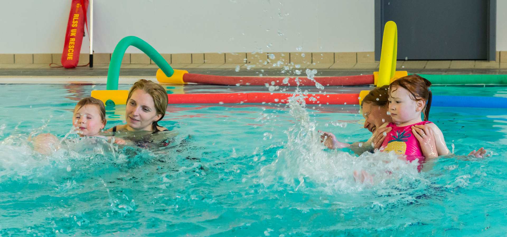 Two young children enjoy some swim lessons