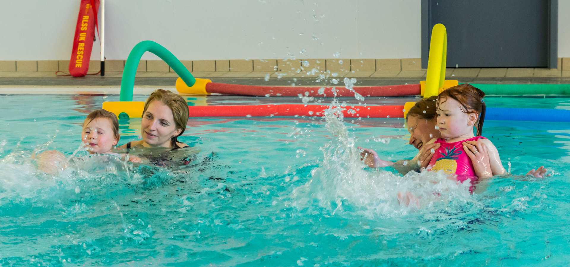 Two young children enjoy some swim lessons