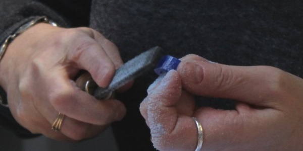 A person using a metal file on an object