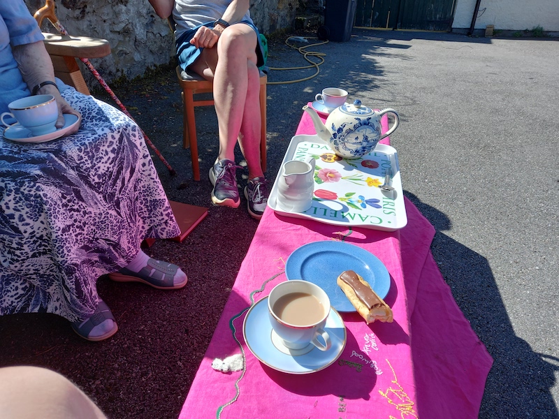 Tea and biscuits being served on top of pink cloth