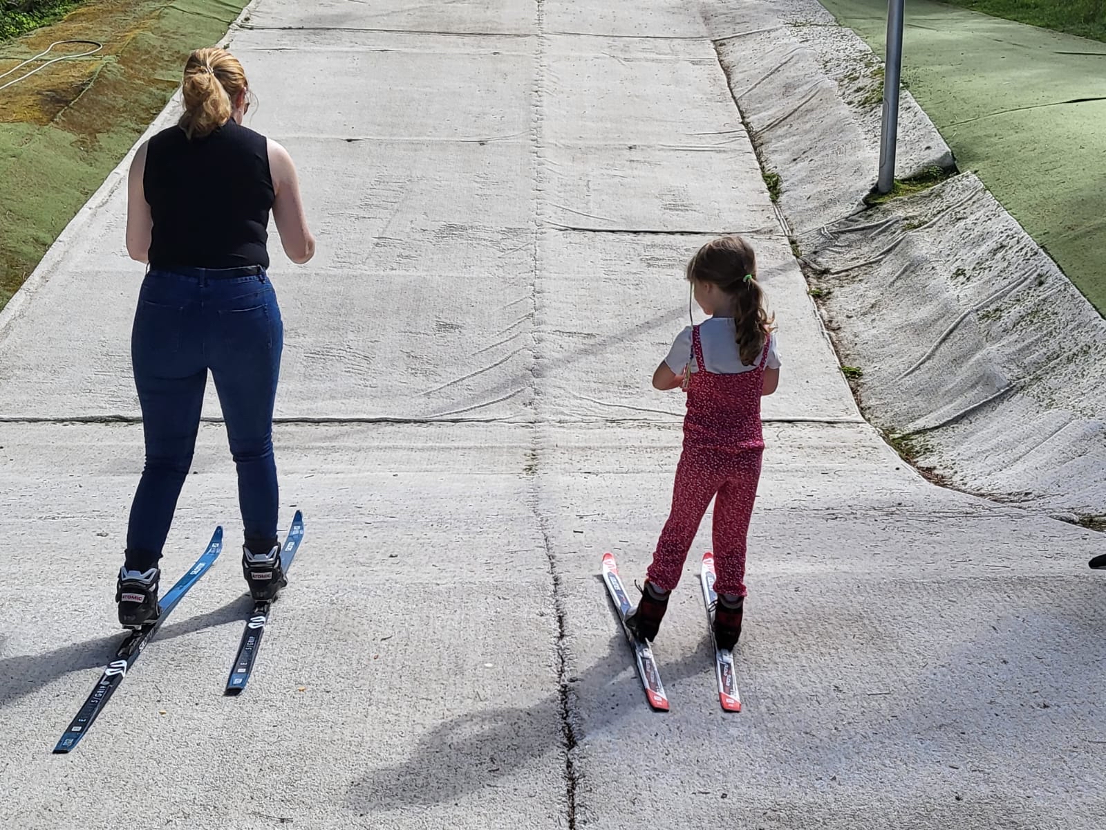 A mother and child skiing down the dry ski slope