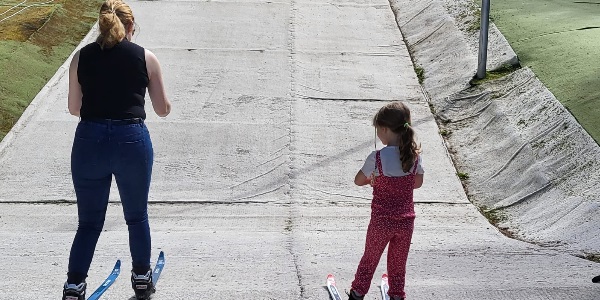 A parent and child enjoying a ski session together