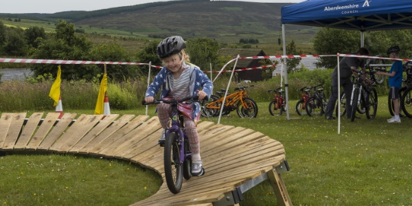 A young girl laughing while biking on the bike track