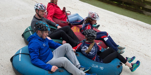 A group of people tubing down a slope