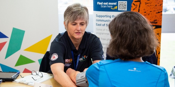 A member of the team taking a customers blood pressure
