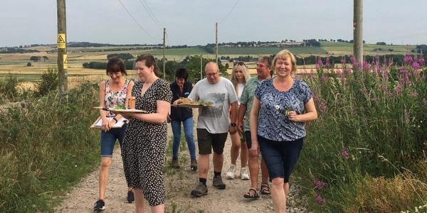 A group of artists walking along a farm track