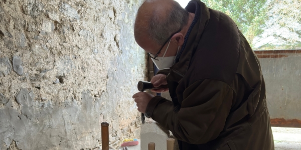 An artist working on a piece of wood