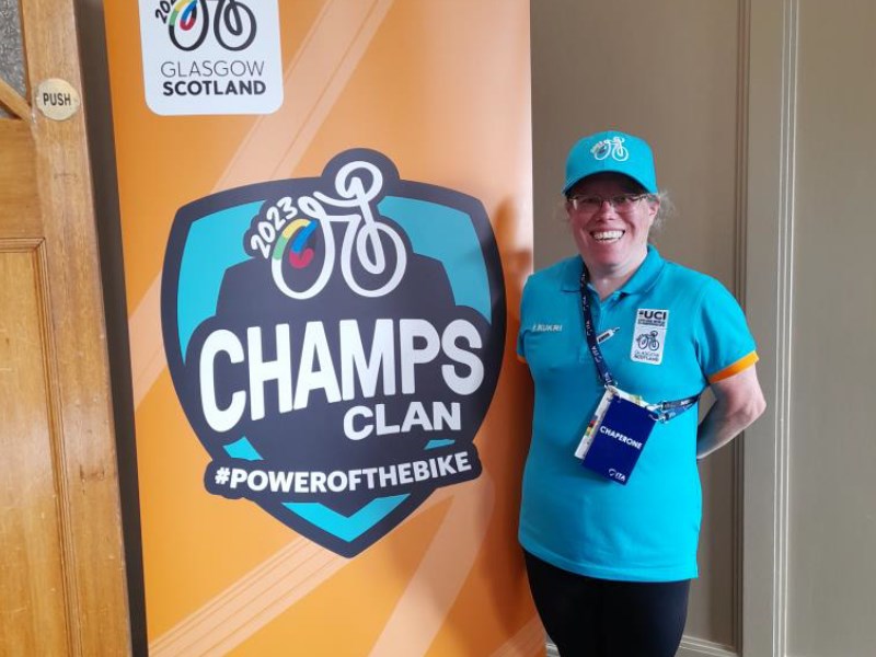 Aberdeenshire volunteer standing in front of a banner advertising the cycling event