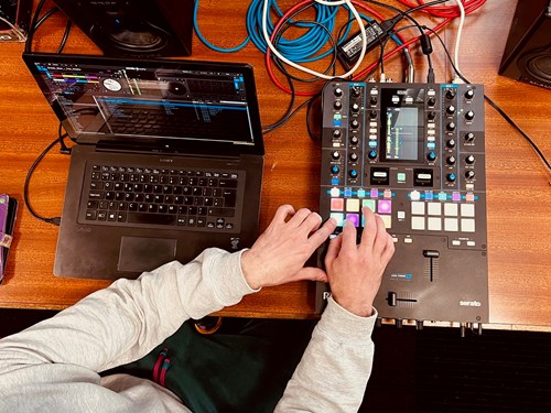 hands of young people using laptop and mini music keyboard