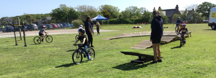 children riding bike across obstacles